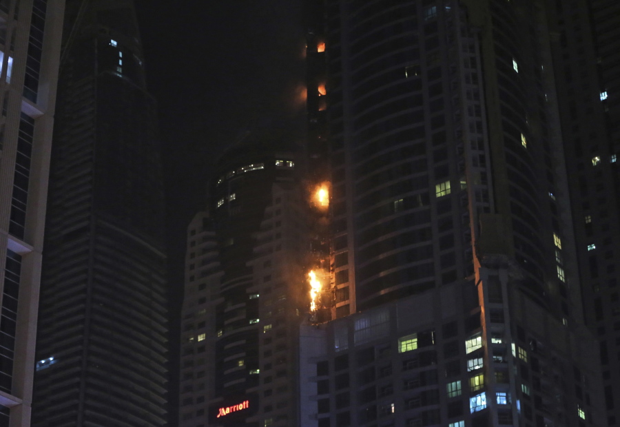 Smoke and fire rise from a high rise building at Marina district in Dubai, United Arab Emirates, Friday, Aug. 4, 2017. The high-rise residential tower has caught fire in the middle of the night, sending plumes of black smoke into the air and debris falling below.
