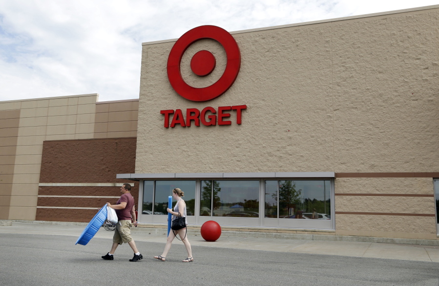 Customers walk with their purchases from a Target store in Methuen, Mass.