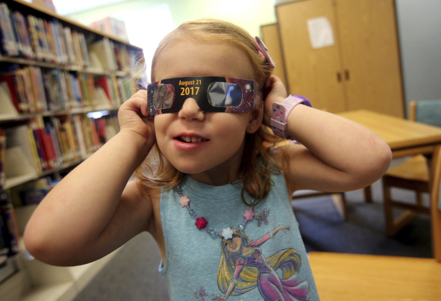 Emmalyn Johnson, 3, tries on eclipse glasses last week at Mauney Memorial Library in Kings Mountain, N.C.