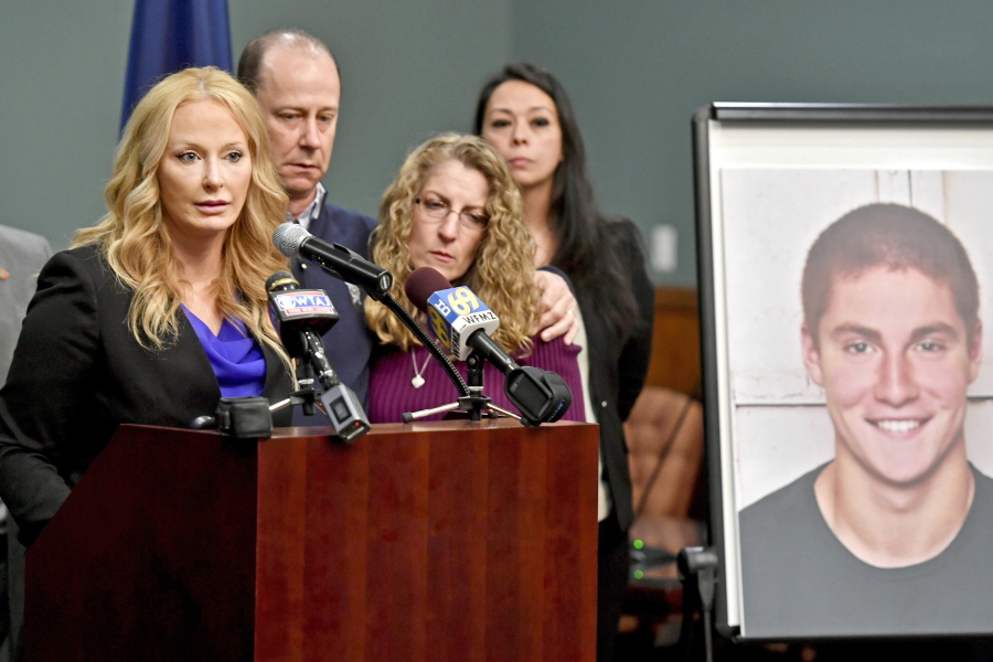 FCentre County, Pa., District Attorney Stacy Parks Miller, left, announces the findings of an investigation into the death of Penn State University fraternity pledge Tim Piazza, seen in photo at right, as his parents, Jim and Evelyn Piazza, second and third from left, stand nearby during a news conference in Bellefonte, Pa. A preliminary hearing is set to resume Thursday, Aug. 10 for members of Penn State University’s now-shuttered Beta Theta Pi fraternity chapter, accused in the Feb. 4 death of 19-year-old Tim Piazza, of Lebanon, N.J., after a night of heavy drinking.