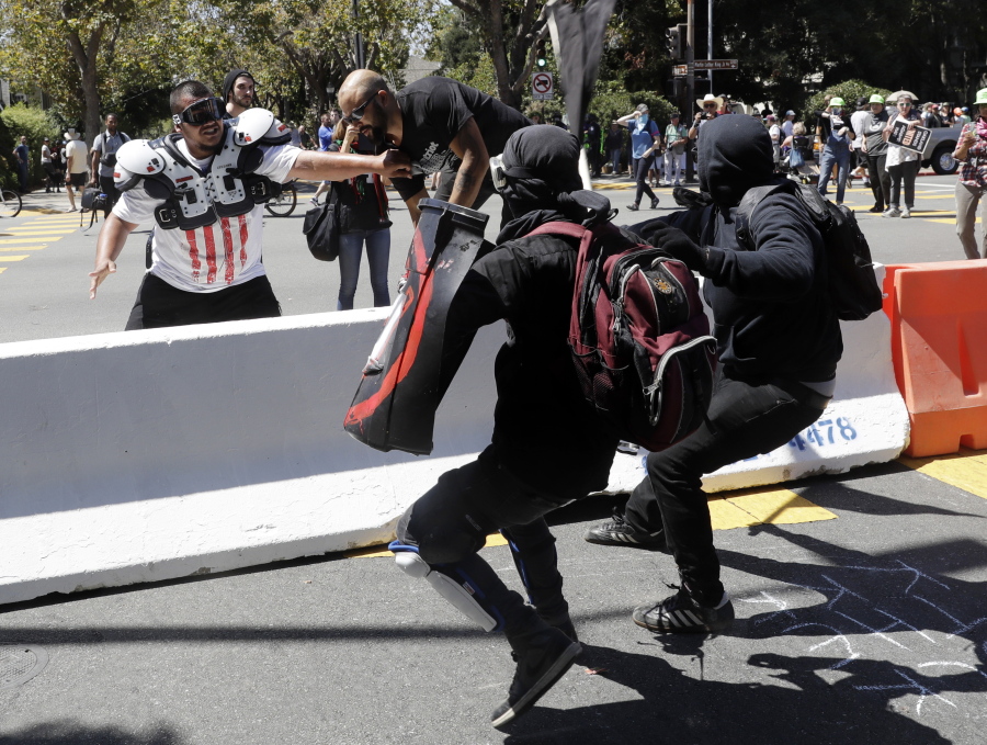 Demonstrator Joey Gibson, second from left, is chased by anti-fascists during a free speech rally Sunday, Aug. 27, 2017, in Berkeley, Calif. Several thousand people converged in Berkeley Sunday for a “Rally Against Hate” in response to a planned right-wing protest that raised concerns of violence and triggered a massive police presence. Several people were arrested for violating rules against covering their faces or carrying items banned by authorities.