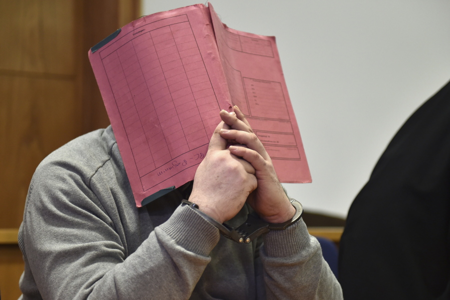 Former nurse Niels Hoegel, accused of multiple murder and attempted murder of patients, covers his face with a file Feb. 26, 2015, at the district court in Oldenburg, Germany. German authorities say Monday they now believe that a nurse who was convicted of killing patients with overdoses of heart medication killed at least 84 people. Niels Hoegel was convicted in 2015 of two murders and two attempted murders at a clinic in the northwestern town of Delmenhorst. Oldenburg police chief Johann Kuehme said Monday authorities have now unearthed evidence of 84 killings.
