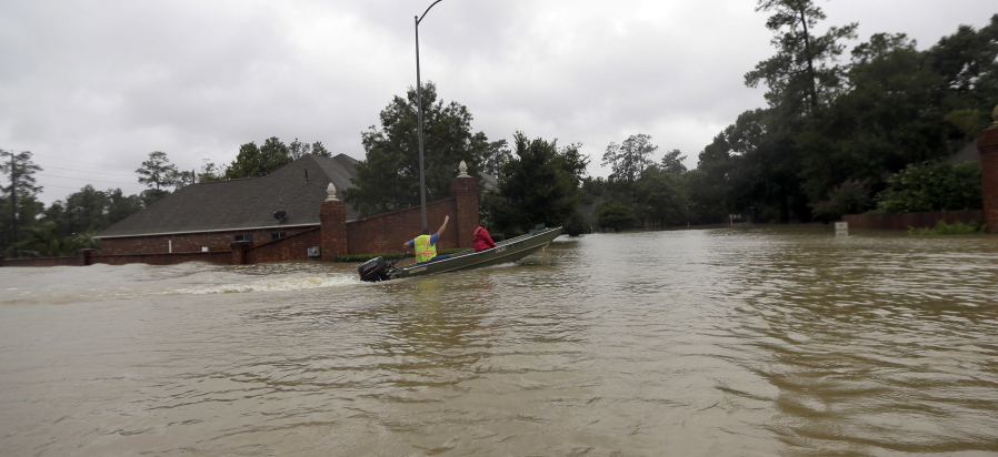 A rescue boat enters a flooded subdivision as floodwaters from Tropical Storm Harvey rise Monday in Spring, Texas. (AP Photo/David J.