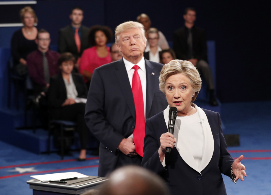 Democratic presidential nominee Hillary Clinton, right, speaks as Republican presidential nominee Donald Trump listens during the second presidential debate at Washington University in St. Louis, Oct. 9, 2016.