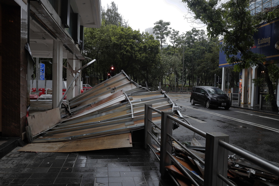 A collapsed wooden wall caused by Typhoon Hato sit on a street in Hong Kong on Wednesday. The powerful typhoon barreled into Hong Kong on Wednesday, forcing offices and schools to close and leaving flooded streets, shattered windows and hundreds of canceled flights in its wake.