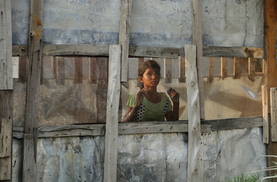 A Rohingya refugee girl looks through a mesh window at a camp set up for the refugees on the outskirts of Jammu, India, on Wednesday. A day after the U.N. chief voiced concern about Indian plans to potentially deport tens of thousands of Muslim Rohingya refugees, an Indian government official said Wednesday that authorities are only working to identify those who fled persecution in neighboring Myanmar, not expel them. An estimated 40,000 Rohingya Muslims have taken refuge in various parts of India, though fewer than 15,000 are registered with the U.N. High Commissioner for Refugees.
