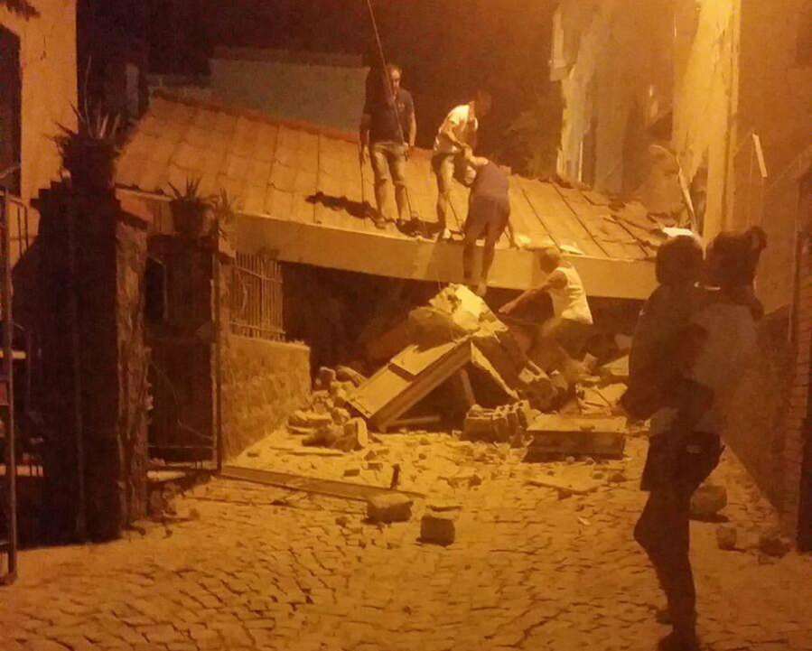 People remove debris after an earthquake hit Ischia island, near Naples, Southern Italy, Monday, Aug. 21, 2017.