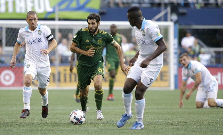 Portland Timbers midfielder Diego Valeri, second from left, drives between Seattle Sounders midfielder Osvaldo Alonso, left, and defender Nouhou (5) in the first half of an MLS soccer match, Sunday, Aug. 27, 2017, in Seattle. (AP Photo/Ted S.