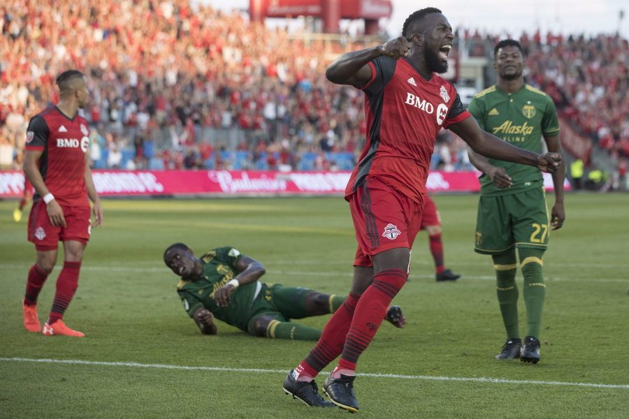 Toronto FC forward Jozy Altidore celebrates after Justin Morrow, left, scored against the Portland Timbers during the second half of an MLS soccer match Saturday, Aug. 12, 2017, in Toronto.