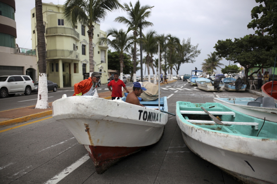 Fishermen move their boats, normally moored in the Gulf of Mexico, onto a coastal road to protect them ahead of the arrival of Tropical Storm Franklin, in the port city of Veracruz, Mexico, on Wednesday. A strengthening Tropical Storm Franklin took aim at Mexico’s central Gulf coast after a relatively mild run across the Yucatan Peninsula, with forecasts saying it would grow into a hurricane before making its second landfall late Wednesday or early Thursday.