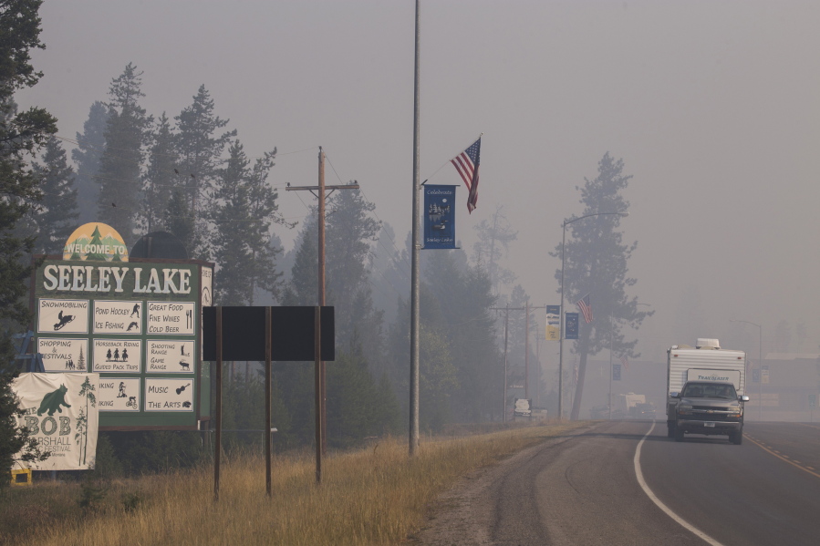 A pickup truck pulls a camper through the wildfire smoke Thursday in Seeley Lake in Missoula County, Mont. kari greer/U.S.