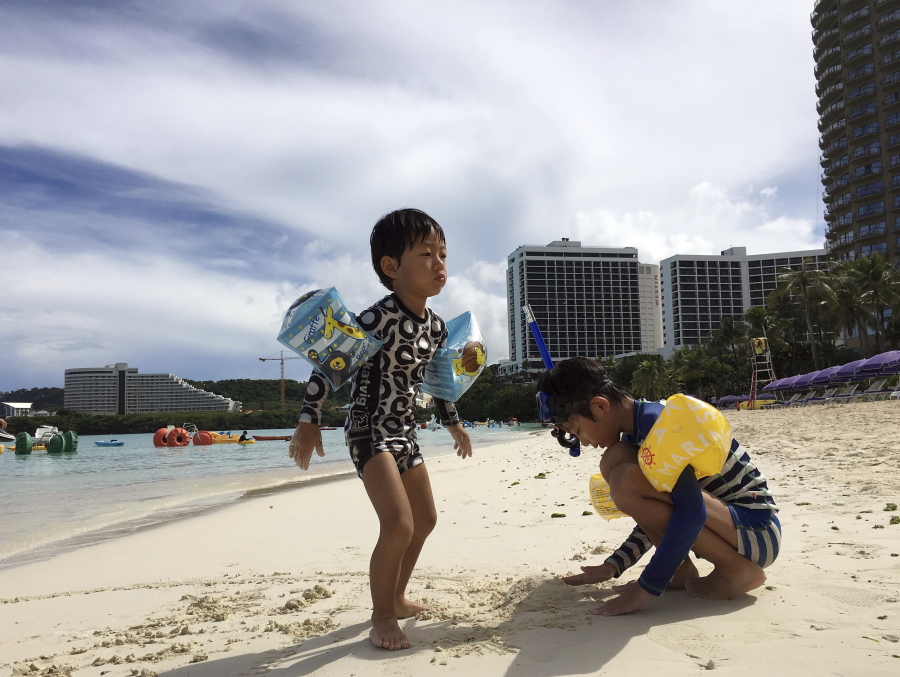 Kids play in the sand in Tumon, Guam on Thursday. The small U.S. territory of Guam has become a focal point after North Korea’s army threatened to use ballistic missiles to create an “enveloping fire” around the island.