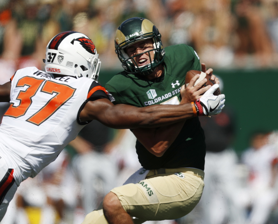 Oregon State linebacker Kee Whetzel, left, tries to tackle Colorado State quarterback Nick Stevens as he looks to pass the ball in the second half of an NCAA college football game Saturday, Aug. 26, 2017, in Fort Collins, Colo.