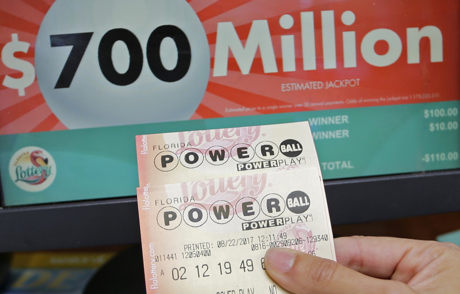A customer shows the Powerball tickets she bought for Wednesday’s drawing on Tuesday in Hialeah, Fla.