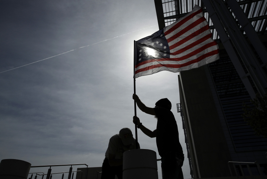 Supporters raise a flag outside of the federal courthouse in Las Vegas in April. A retrial is nearing an end in Nevada for four men facing decades in prison for bringing assault-style weapons to a confrontation that stopped government agents from rounding up cattle near anti-government figure Cliven Bundy’s ranch in April 2014.