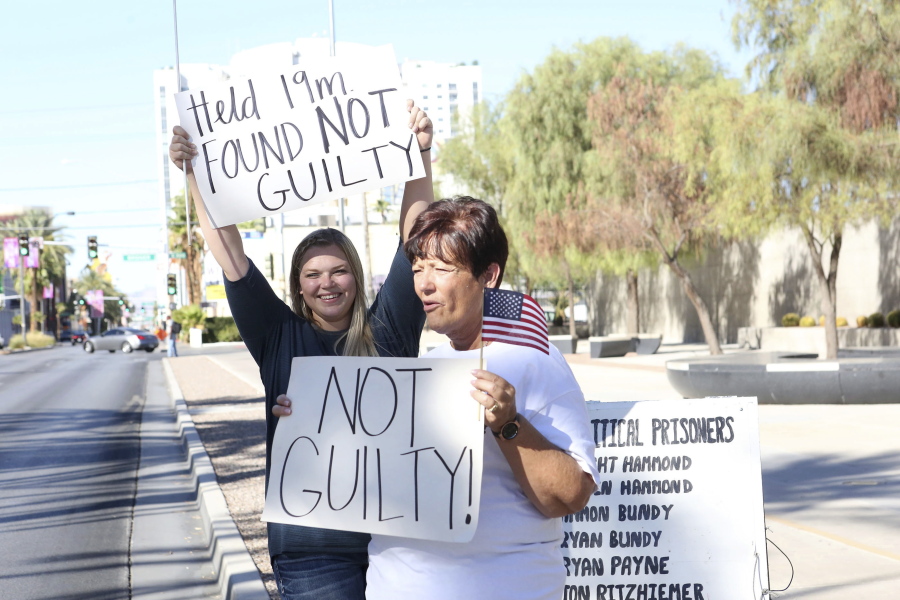 Cliven Bundy’s daughter, Bailey Bundy Logue, left, and Margaret Houston wave signs in front of the Lloyd George U.S. Courthouse in Las Vegas on Tuesday after the not guilty verdict in the Bunkerville, Nev., standoff retrial.