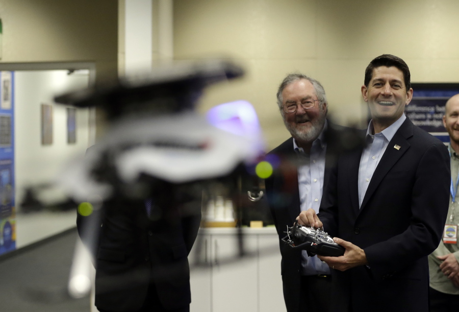 House Speaker Paul Ryan, right, laughs as he flies a drone straight at the cameras during his visit to Intel in Hillsboro, Ore., on Wednesday.