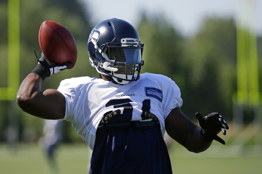 Seattle Seahawks strong safety Kam Chancellor passes the football while playing catch at the start of NFL football training camp, Tuesday, Aug. 1, 2017, in Renton, Wash. (AP Photo/Ted S.