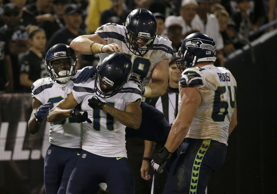 Seattle Seahawks wide receiver Kenny Lawler (11) celebrates with teammates after scoring a touchdown during the second half of Seattle’s 17-13 win.