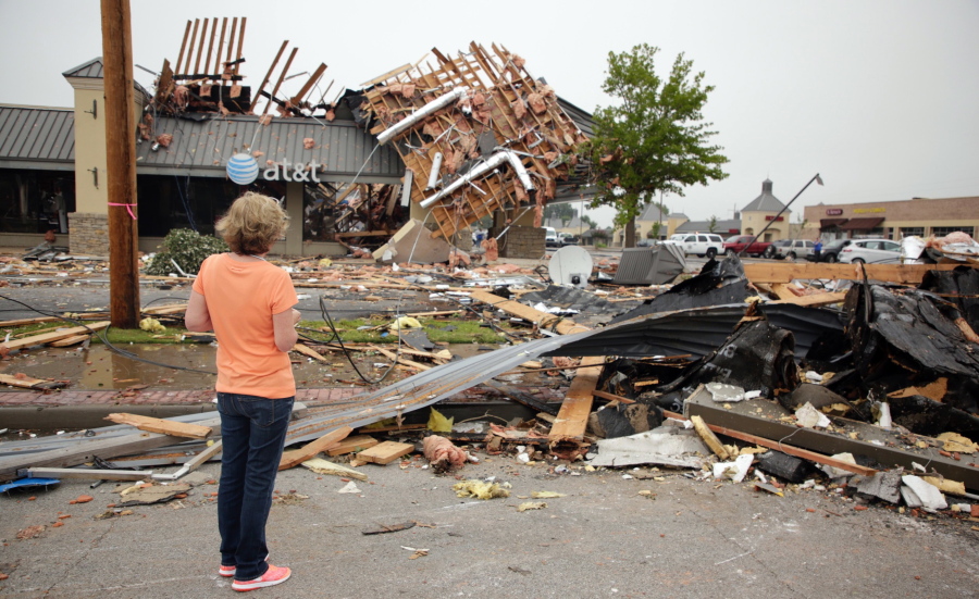 Property manager Gail Fair-Tucker looks at tornado damage Monday at Highland Plaza in Tulsa, Okla.