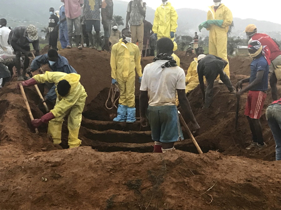 Volunteers prepare to bury coffins during a mass funeral for victims of heavy flooding and mudslides in Regent at a cemetery in Sierra Leone, Freetown, Thursday, Aug. 17, 2017. The government has begun burying the hundreds of people killed earlier this week in mudslides in Sierra Leone's capital, and it warned Thursday of new danger from a large crack that has opened on a mountainside where residents were told to evacuate.
