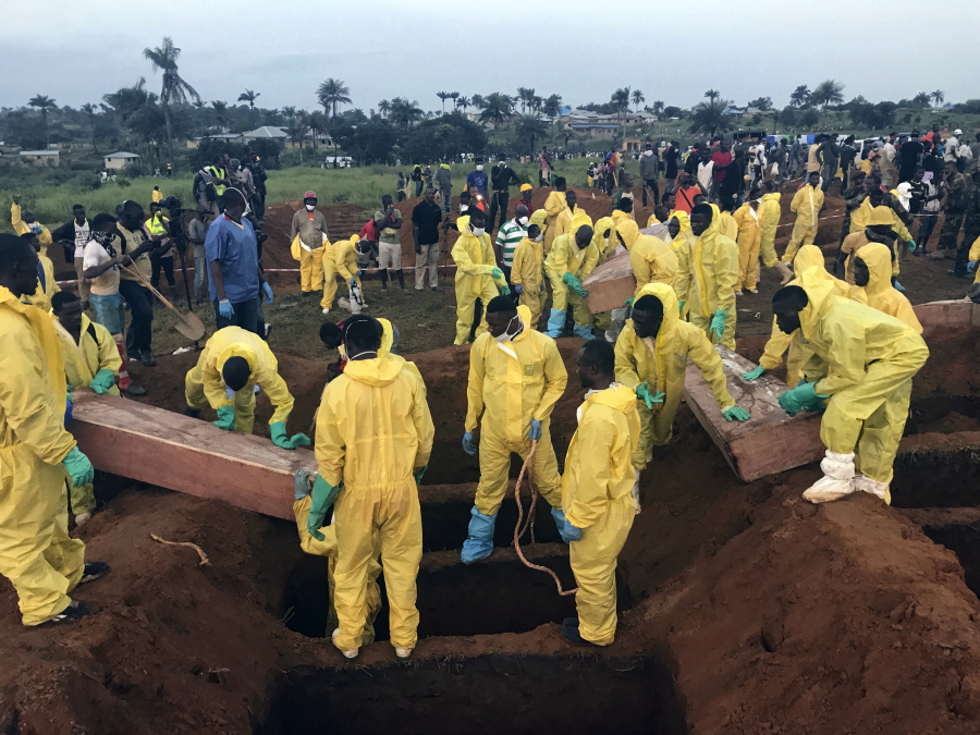 Volunteers handle a coffin during a mass funeral Thursday for victims of heavy flooding and mudslides in Regent at a cemetery in Freetown, Sierra Leone. Churches across Sierra Leone held special services Sunday, Aug. 20 in memory of the more than 500 people who were killed in mudslides and flooding last week.