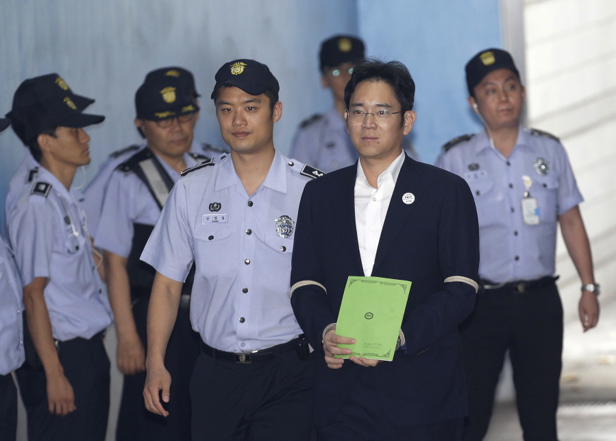 Lee Jae-yong, second from right, vice chairman of Samsung Electronics Co., arrives for his trial at the Seoul Central District Court in Seoul, South Korea, on Monday. South Korean prosecutors recommended imprisoning a billionaire Samsung heir for 12 years on Monday, asking court to convict him of bribery and other crimes in a national corruption scandal.