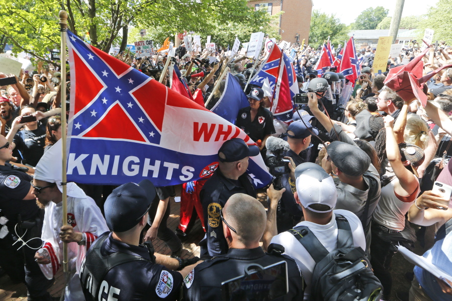 This July 8, 2017 photo shows members of the KKK escorted by police past a large group of protesters during a KKK rally in Charlottesville, Va. Some white Southerners are again advocating for what the Confederacy tried and failed to do in the 1860s: secession from the Union. So-called Southern nationalists are within the group of demonstrators who are fighting the removal of Confederate monuments around the South.