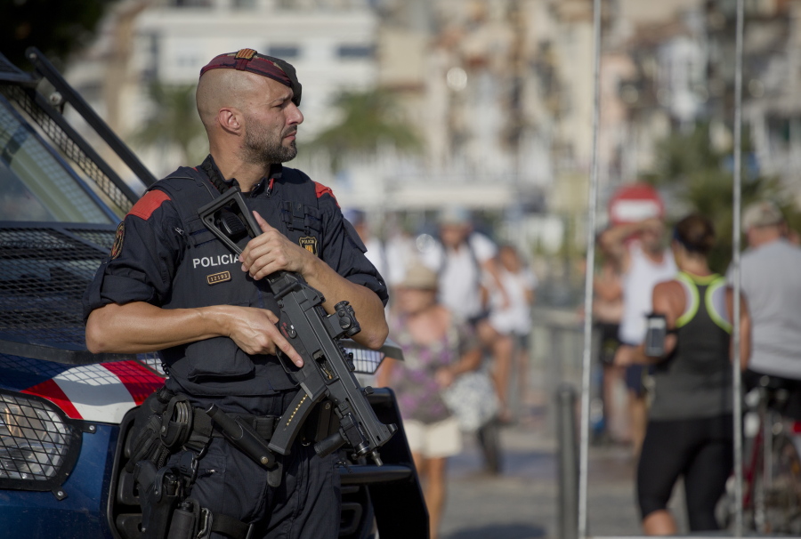 An armed policeman stands on the spot where terrorist were shot by police in Cambrils, Spain, Friday, Aug. 18, 2017. Spanish police on Friday shot and killed five people carrying bomb belts who were connected to the Barcelona van attack that killed at least 13, as the manhunt intensified for the perpetrators of Europe’s latest rampage claimed by the Islamic State group.