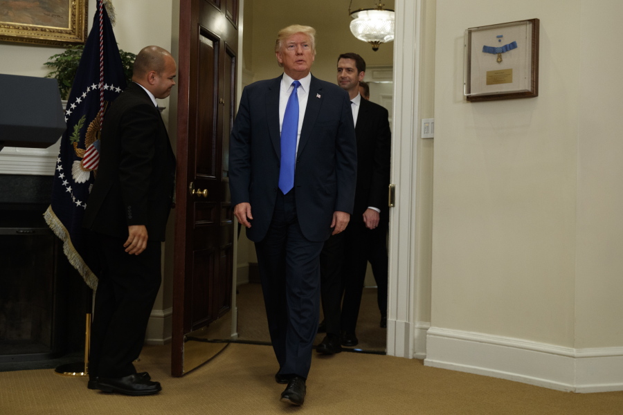 President Donald Trump, followed by Sen. Tom Cotton, R-Ark., arrives in the Roosevelt Room of the White House in Washington, Wednesday to unveil legislation that would place new limits on legal immigration.