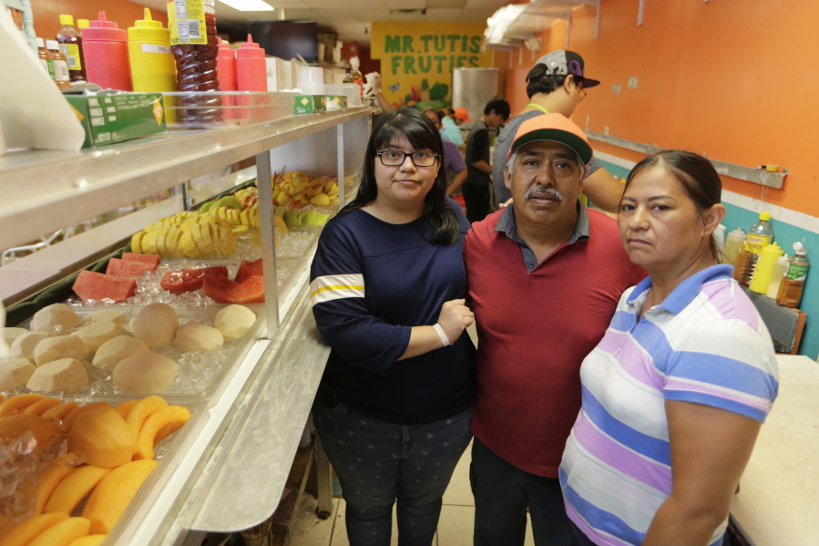 Diana Resendiz, from left, Alberto Resendiz, and Maribel Resendiz, pose June 27 at their business, Mr. Tutis Fruties, in Florida City, Fla. Maribel Resendiz and her husband came to the U.S. from Mexico, sold cool drinks to workers in the tomato fields of South Florida and eventually opened a bustling shop in a strip mall offering fruit smoothies and tacos. Now she is preparing for the possibility she’ll have to leave it all behind.