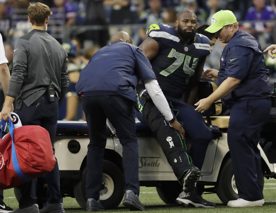 Seattle Seahawks offensive tackle George Fant is helped onto a cart after he went down on a play against the Minnesota Vikings during the first half of an NFL football preseason game, Friday, Aug. 18, 2017, in Seattle.
