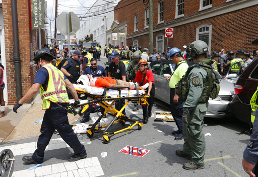 Rescue personnel help injured people after a car ran into a large group of protesters after an white nationalist rally in Charlottesville, Va., Saturday, Aug. 12, 2017.  The nationalists were holding the rally to protest plans by the city of Charlottesville to remove a statue of Confederate Gen. Robert E. Lee. There were several hundred protesters marching in a long line when the car drove into a group of them.