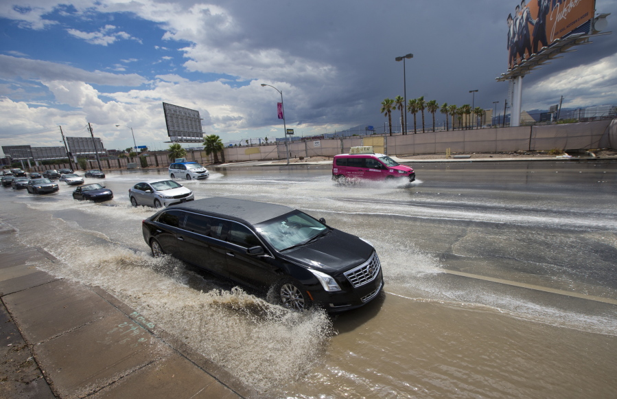 Traffic passes through floodwaters along Swenson Street near Tropicana Avenue after a thunderstorm passed through in Las Vegas on Friday, Aug. 4, 2017.