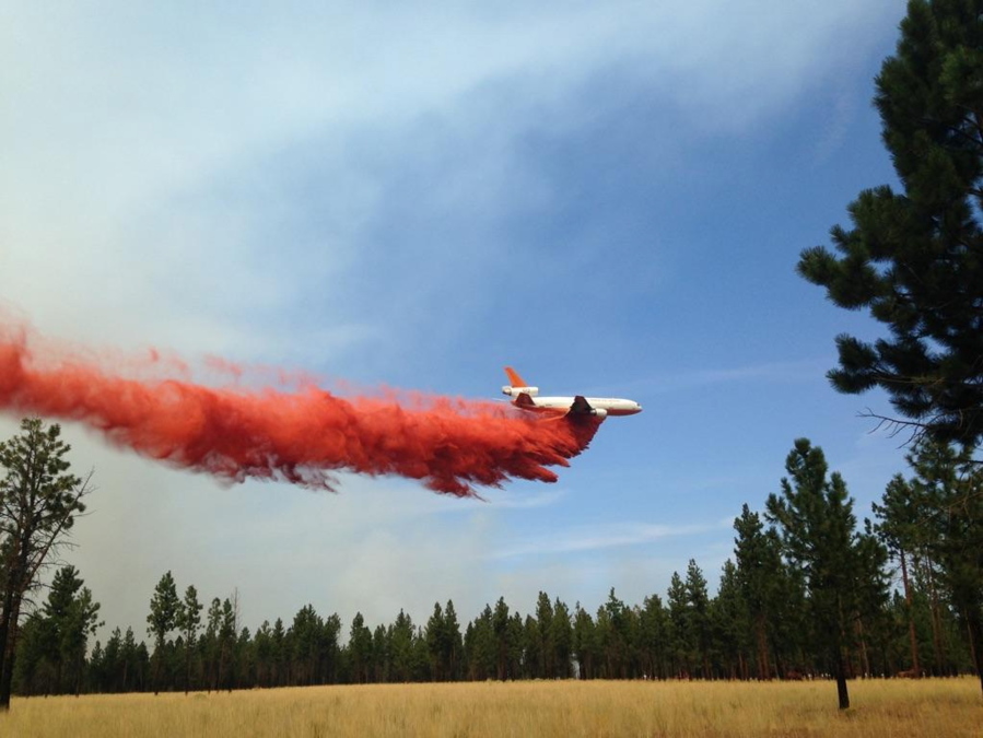 A DC-10 tanker helping with air support at the Milli Fire near Sisters, Ore., drops fire retardant. (U.S.