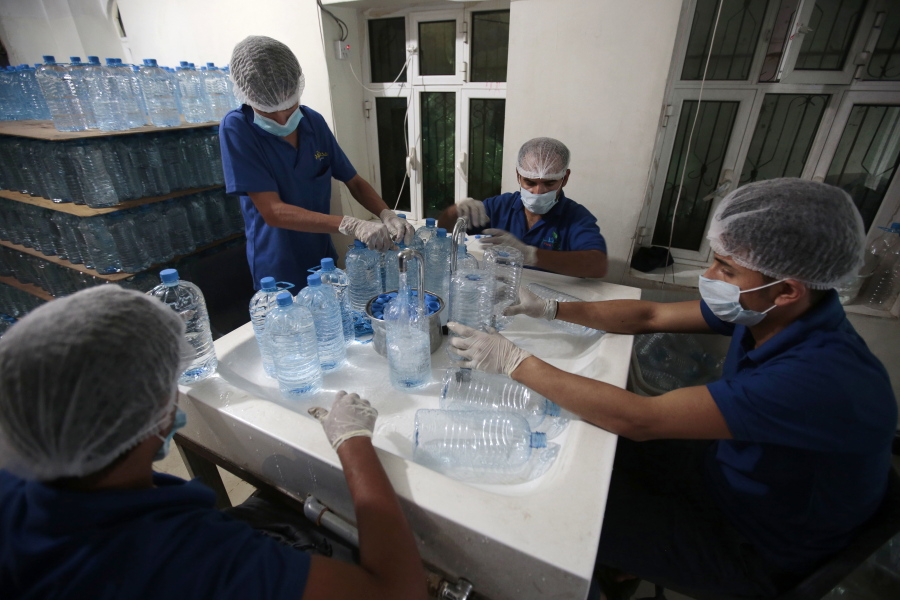 Workers fill bottles with water at the mineral water refilling station in Sanaa, Yemen. Yemen’s raging two-year conflict has served as an incubator for lethal cholera.