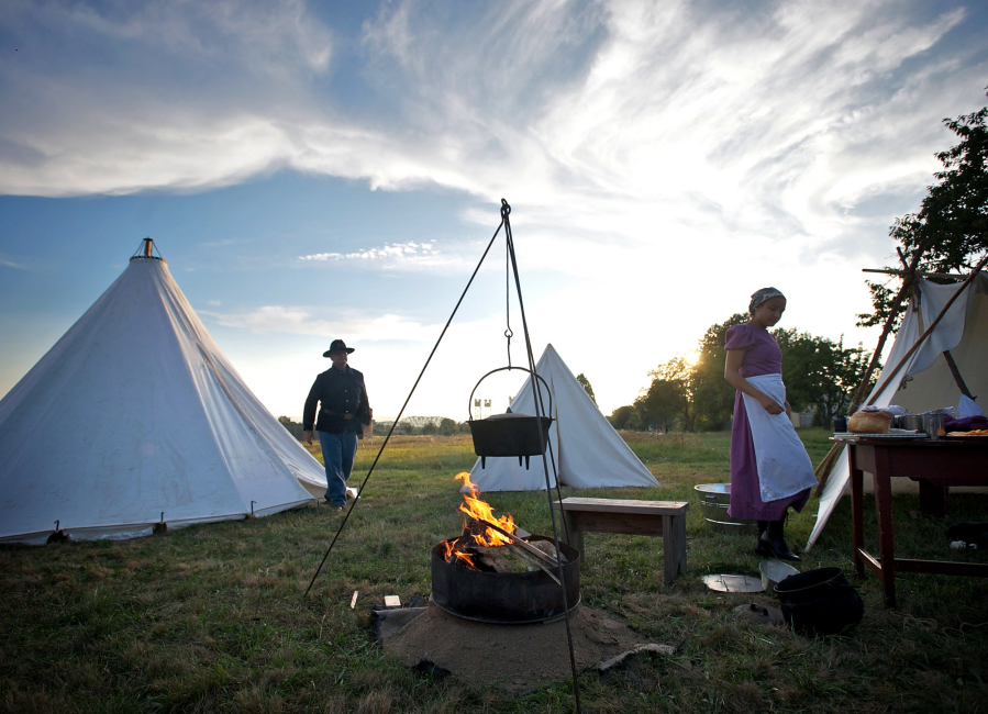 Ret. U.S. Army Col. Dale Lazo, 57, of Vancouver, who is depicting a U.S. Army soldier from the American Indian War era, and Lydia Sheehey, 25, of Portland, depicting a worker in the Laundress Camp from the 1890s, take part in the Campfires and Candlelight event at Fort Vancouver National Historic Site on Saturday, Sept. 14, 2013.