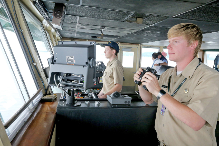 In the wheelhouse of the ferry Issaquah, interns John Bresnahan, left, at the wheel, and Sebstian Jewell, right, approach Fauntleroy Ferry Terminal.