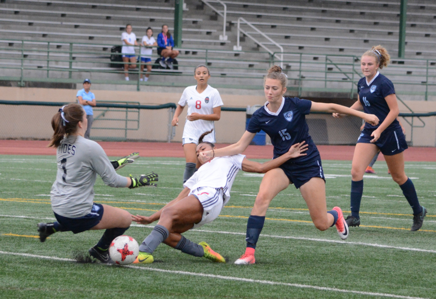 Union's MaKayla Woods, center, attempts to shoot past Gig Harbor goalkeeper Auna Havens on Thursday at McKenzie Stadium. Maddie Goss would score a few seconds later in Union's 4-1 win.