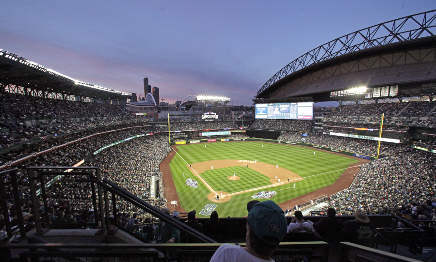 The sun sets beyond the Seattle Mariners ballpark in the third inning of the team's baseball game against the Oakland Athletics on Friday, April 8, 2016, in Seattle.