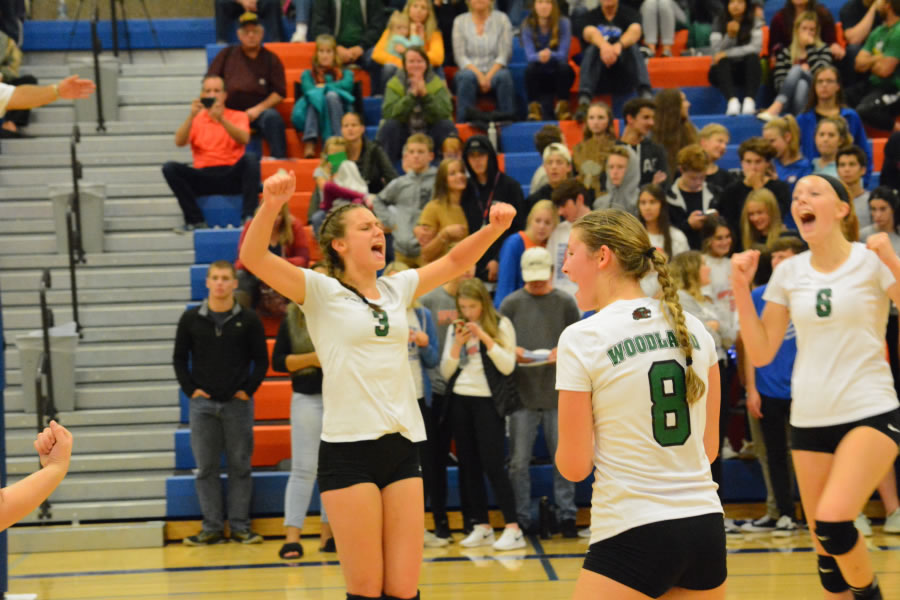 From left, Nicole Guthrie, Vanessa Franke and Emma Swett celebrate a point for Woodland in a volleyball match against Ridgefield on Thursday.