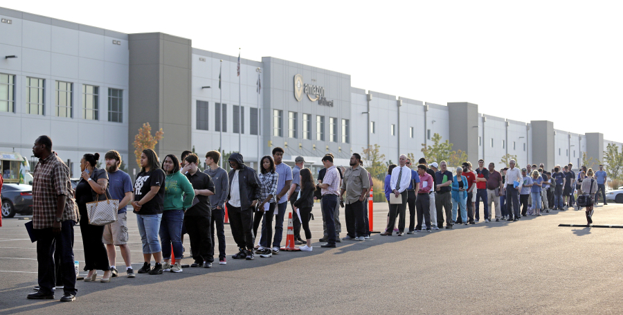 Applicants wait in line to enter a job fair Aug. 2 at an Amazon fulfillment center in Kent.