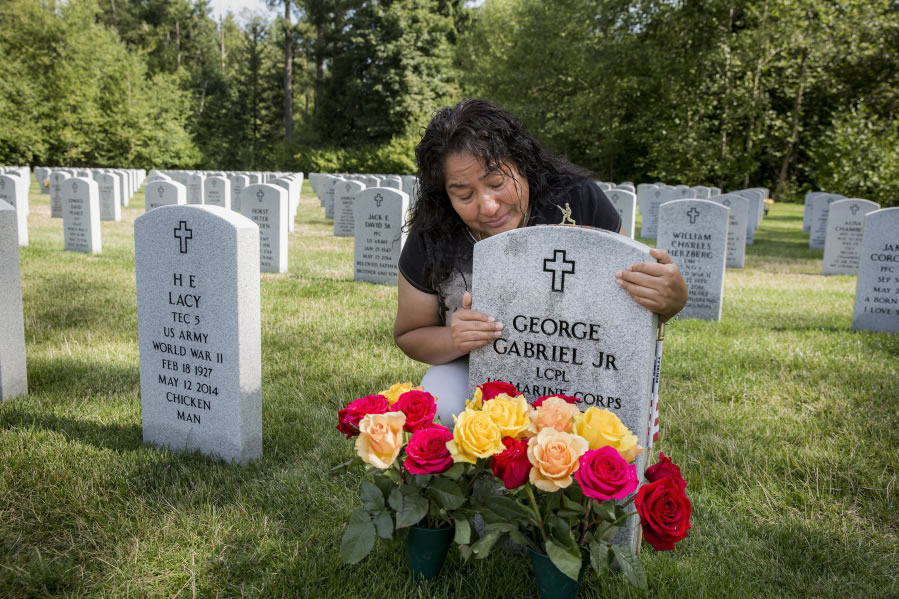 Lourdes Reyes hugs the headstone of her son, George Gabriel Jr., a Marine on leave who was shot and killed in his car as he was waiting for a parking space at Reyes’ apartment building three years ago. “What I hope is, I just want justice,” Reyes says.