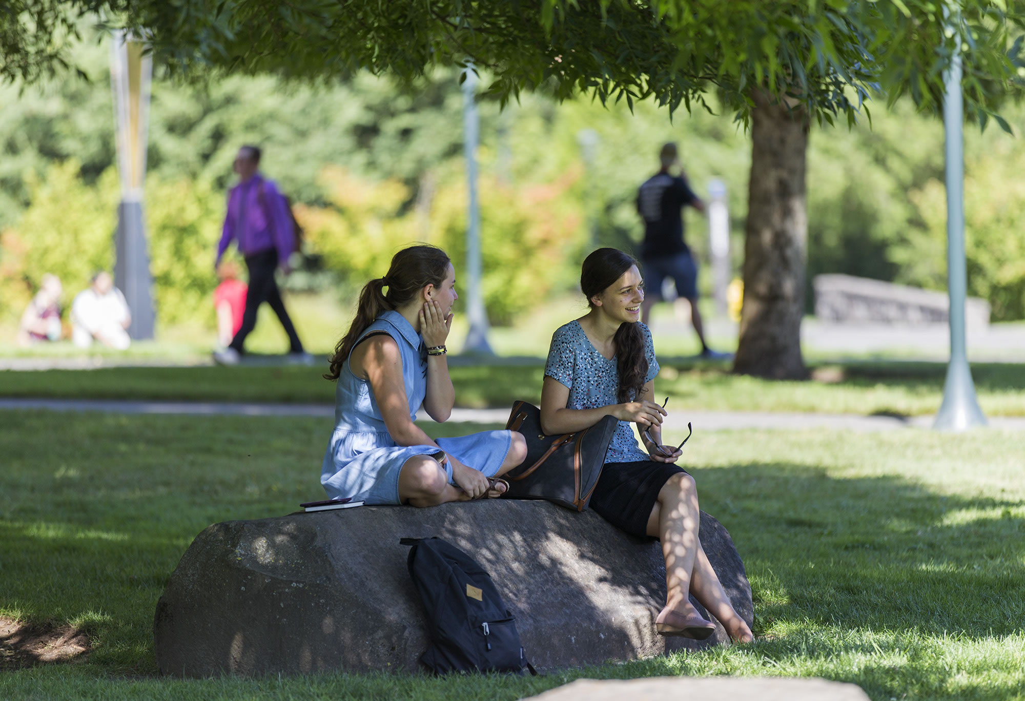 Vicki Tolmacheva, 21, left, and Olga Boligar, 18, both seniors from Vancouver, chat in the shade on the WSU Vancouver campus the first week of school.