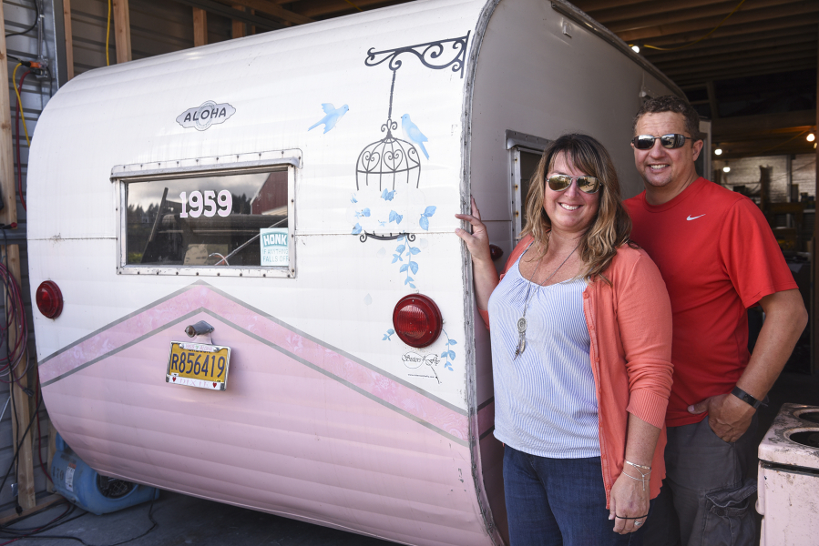 René Perret and Jeremy Ralston, owners of Down River Vintage Trailer Restoration, stand next to a 1959 Aloha trailer they're renovating in their shop in Woodland.