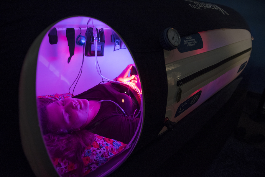 Hyperbaric oxygen therapy technician Hannah Young of Carson demonstrates the use of the oxygen chamber at In Light Hyperbarics in Vancouver. Young said she tries to use the therapy a few times a week when she has a break between appointments.