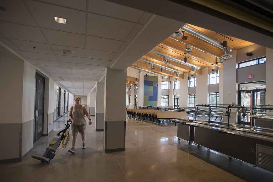 Custodian Trish Happs makes her way through the cafeteria shared by the new Columbia River Gorge Elementary School and replacement Jemtegaard Middle School. The 122,000-square-foot campus, funded thanks to a $57.7 million bond passed in February 2015, opens on Thursday.