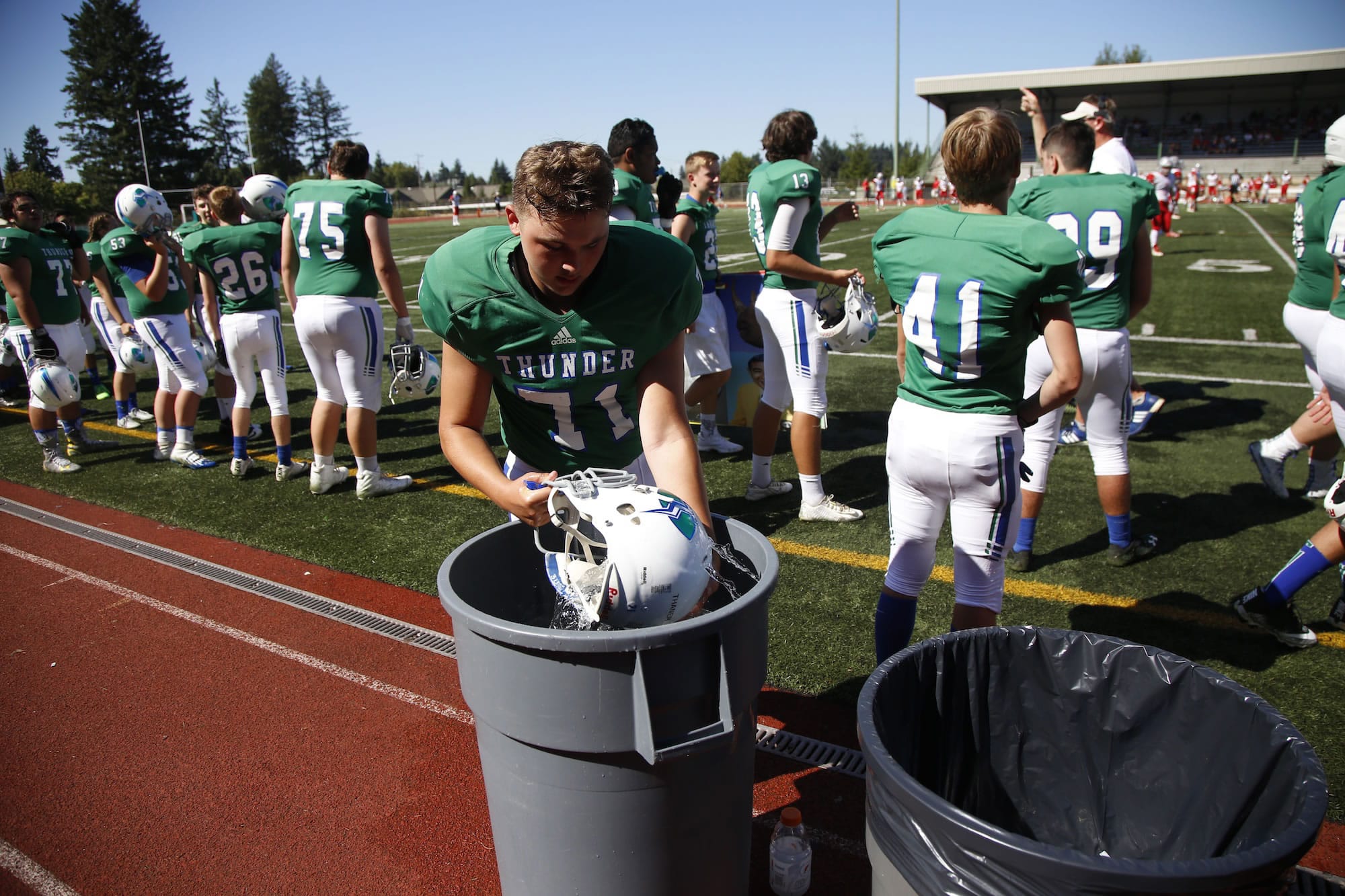 Mountain View's Michael Thanem dips his helmet in ice water during game vs. Ferris  on Saturday afternoon at McKenzie Stadium.