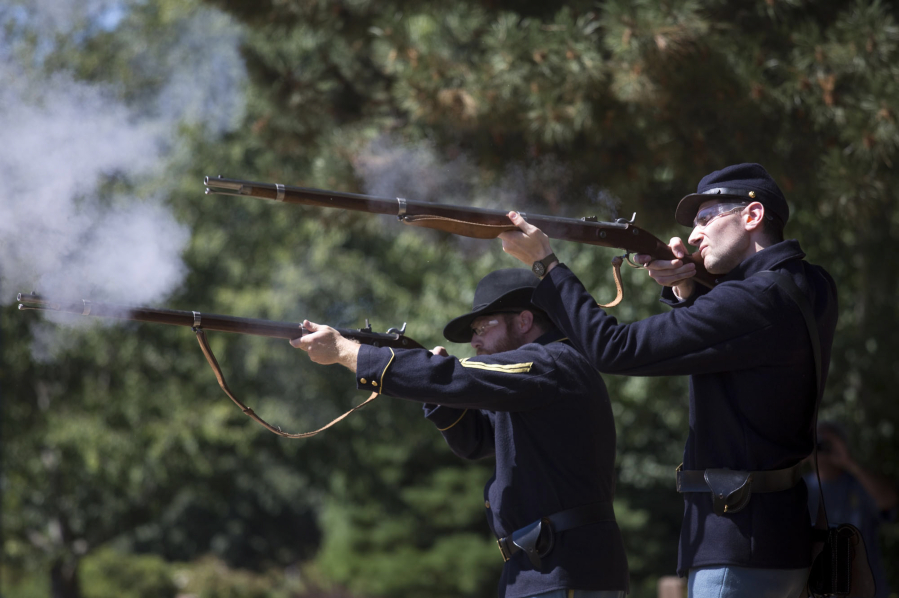 Park rangers Brett Roth, left, and Tyler Gordon demonstrate how historical weapons were used on the Fort Vancouver Parade Ground on Saturday. The demonstrations will return during the Campfires & Candlelight event happening Sept. 9.