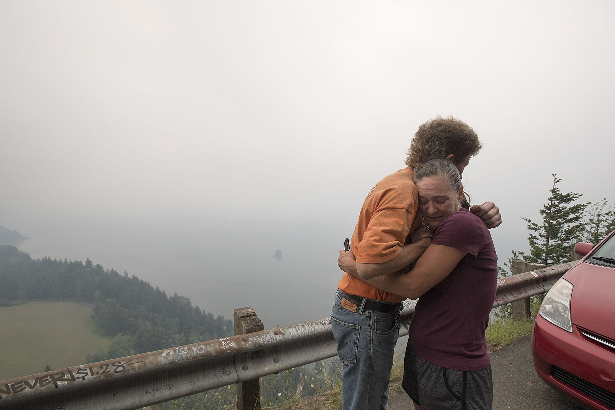 James Wilhelm, left, of Stevenson pauses to comfort Sheri Bousquet of Vancouver at the Cape Horn overlook along Highway 14 as she fights back tears watching the Columbia River Gorge burn from wildfires Tuesday morning, Sept. 5, 2017. She called the area her "sanctuary" and said she visits often because of the beauty. "It's like my church," she said.